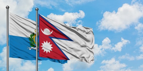 San Marino and Nepal flag waving in the wind against white cloudy blue sky together. Diplomacy concept, international relations.