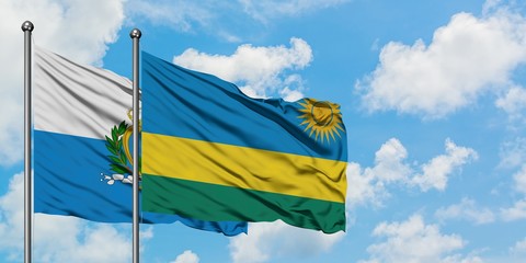 San Marino and Rwanda flag waving in the wind against white cloudy blue sky together. Diplomacy concept, international relations.