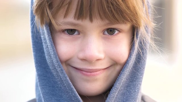 Portrait of happy child girl in warm clothes in autumn outdoors.
