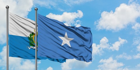 San Marino and Somalia flag waving in the wind against white cloudy blue sky together. Diplomacy concept, international relations.