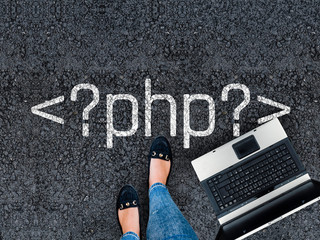 PHP programming language. .A woman steps to a laptop and php tag on asphalt road
