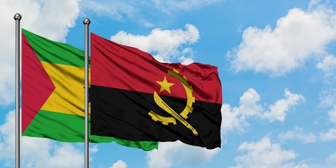 Sao Tome And Principe and Angola flag waving in the wind against white cloudy blue sky together. Diplomacy concept, international relations.