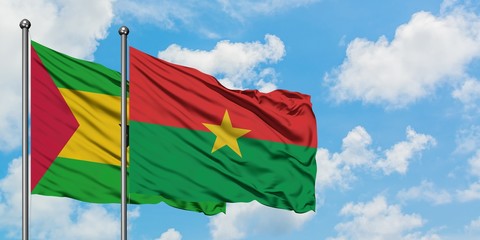 Sao Tome And Principe and Burkina Faso flag waving in the wind against white cloudy blue sky together. Diplomacy concept, international relations.