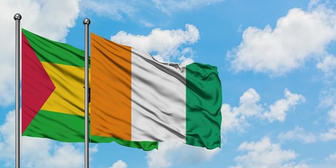 Sao Tome And Principe and Cote D'Ivoire flag waving in the wind against white cloudy blue sky...