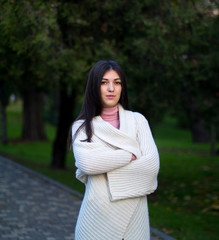 young female in white cardigan in the autumn park