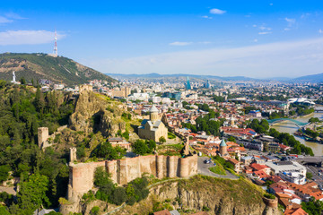Panorama of the old town on Sololaki hill, crowned with Narikala fortress, the Kura river and cars traffic with blure in Tbilisi, Georgia