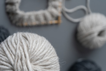 Close-up of a ball of natural yarn from wool and alpaca in natural color on a gray background. Knitting at home during the day, handmade, hobby. Close-up
