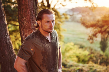 Beautiful man in the forest. Good weather. Beautiful orange colored sunlight