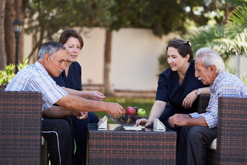 Professional helpful caregiver and a senior man during home visit