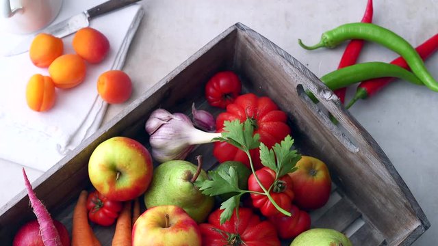 Frisches Bio Gem&uuml;se und Obst in einer Holzkiste. Petersilie bewegt sich im Wind