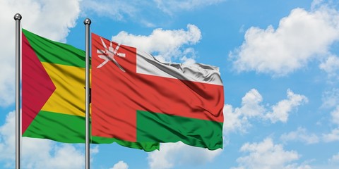 Sao Tome And Principe and Oman flag waving in the wind against white cloudy blue sky together. Diplomacy concept, international relations.