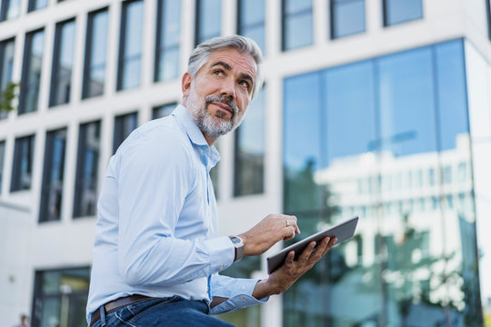 mature, businessman using tablet in the city - Powered by Adobe