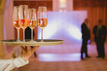 Waiter serving champagne on a tray