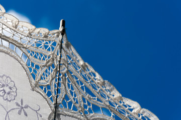 A genteel lace parasol contrasts against a bright blue sky in historic downtown Savannah, Georgia, creating an interesting abstract.