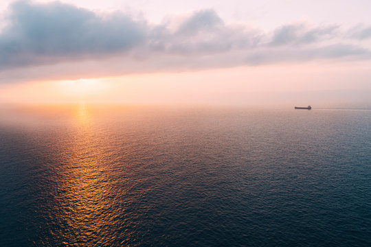 Cargo ship sailing towards sunset at horizon, Mallorca, Spain