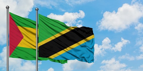 Sao Tome And Principe and Tanzania flag waving in the wind against white cloudy blue sky together. Diplomacy concept, international relations.