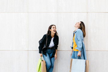 Two friends laughing during shopping