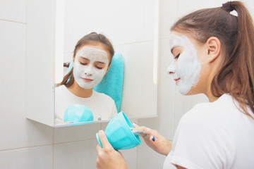 Fototapeta premium Health and beauty. Facial skin care. Young girl makes a moisturizing cleansing face mask