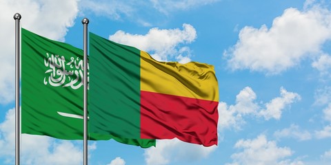 Saudi Arabia and Benin flag waving in the wind against white cloudy blue sky together. Diplomacy concept, international relations.