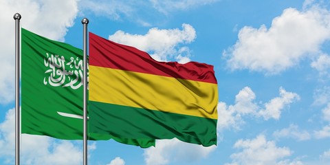 Saudi Arabia and Bolivia flag waving in the wind against white cloudy blue sky together. Diplomacy concept, international relations.