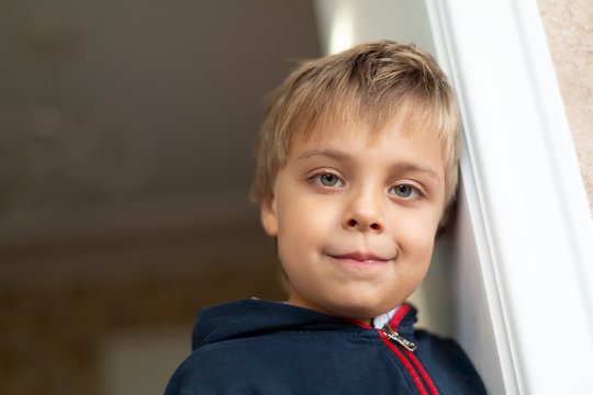 Portrait of little boy leaning against door case