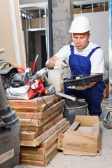 Professional builder checking tools and materials while getting ready for construction works indoors