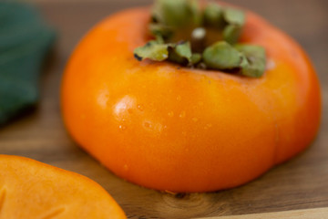 Macro of persimmon fruit on wooden board