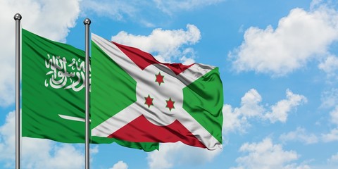 Saudi Arabia and Burundi flag waving in the wind against white cloudy blue sky together. Diplomacy concept, international relations.