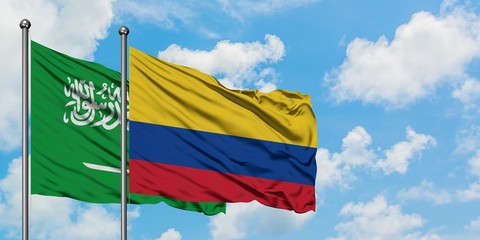 Saudi Arabia and Colombia flag waving in the wind against white cloudy blue sky together. Diplomacy concept, international relations.