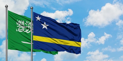 Saudi Arabia and Curacao flag waving in the wind against white cloudy blue sky together. Diplomacy concept, international relations.
