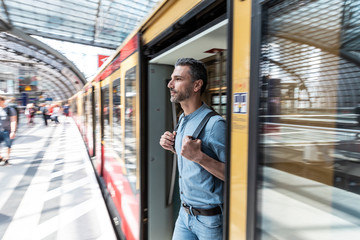 Man disembarking from train at the station platform, Berlin, Germany