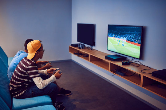 Teenage friends playing video game in an amusement arcade