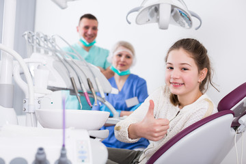 Girl patient in dental office showing ok gesture