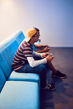 Teenage friends playing video game in an amusement arcade