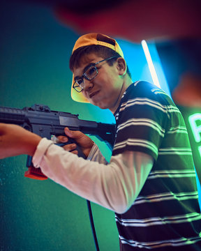 Teenage boy shooting with gun in an amusement arcade