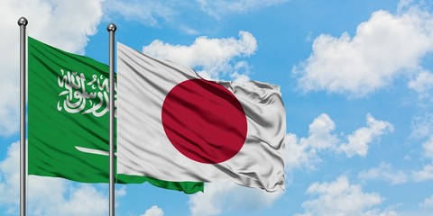 Saudi Arabia and Japan flag waving in the wind against white cloudy blue sky together. Diplomacy concept, international relations.