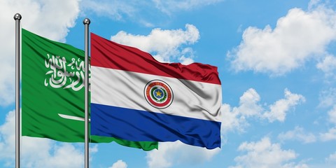 Saudi Arabia and Paraguay flag waving in the wind against white cloudy blue sky together. Diplomacy concept, international relations.