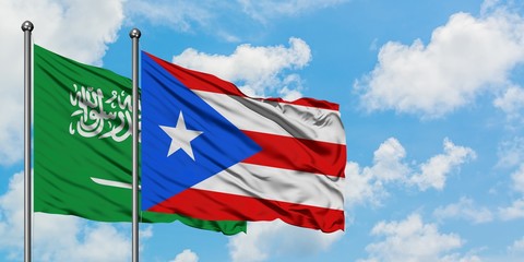 Saudi Arabia and Puerto Rico flag waving in the wind against white cloudy blue sky together. Diplomacy concept, international relations.