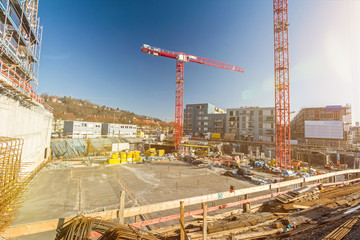 Large building site with foundations and cranes and scenic lens flareLarge building site with...
