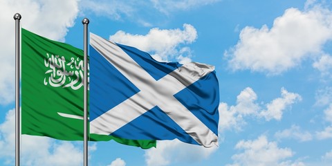Saudi Arabia and Scotland flag waving in the wind against white cloudy blue sky together. Diplomacy concept, international relations.