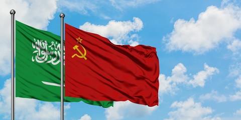 Saudi Arabia and Soviet Union flag waving in the wind against white cloudy blue sky together....