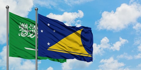 Saudi Arabia and Tokelau flag waving in the wind against white cloudy blue sky together. Diplomacy concept, international relations.