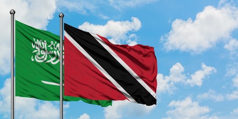 Saudi Arabia and Trinidad And Tobago flag waving in the wind against white cloudy blue sky together. Diplomacy concept, international relations.