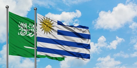 Saudi Arabia and Uruguay flag waving in the wind against white cloudy blue sky together. Diplomacy concept, international relations.