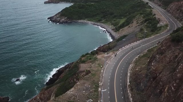 This is still a camera filming a road on the seashore on which the transport goes. In Vietnam
