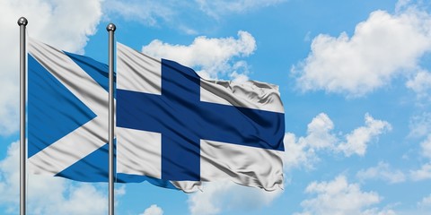 Scotland and Finland flag waving in the wind against white cloudy blue sky together. Diplomacy...