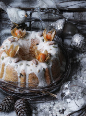 food photography of tasty christmas cake side view with winter decor on a light wooden background close up