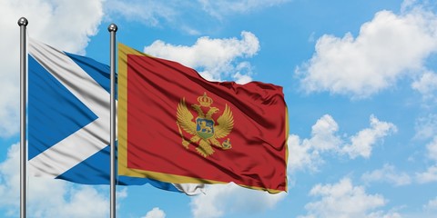 Scotland and Montenegro flag waving in the wind against white cloudy blue sky together. Diplomacy concept, international relations.