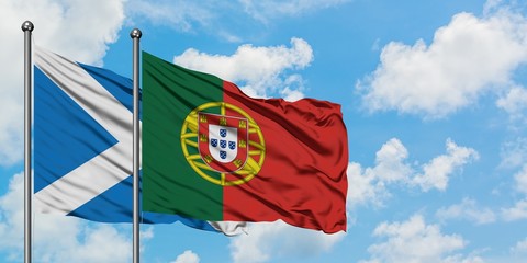 Scotland and Portugal flag waving in the wind against white cloudy blue sky together. Diplomacy concept, international relations.