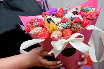 A bouquet of chocolate covered strawberries with different toppings